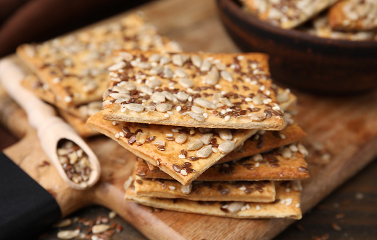 Knäckebrot mit verschiedenen Kernen auf einem Holzbrett.