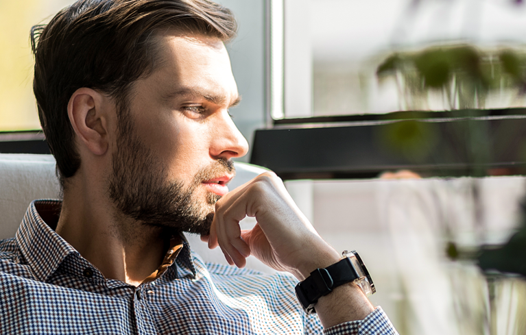 Junger Mann schaut nachdenklich in die Ferne