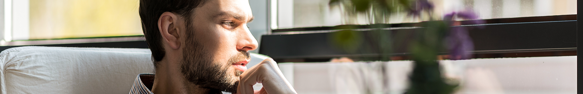 Junger Mann schaut nachdenklich in die Ferne