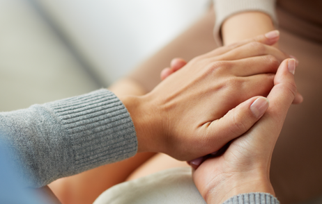 Eine Frau nimmt die Hände einer anderen in ihre