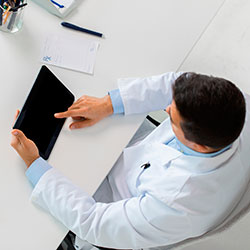 Arzt am i-pad sitzend