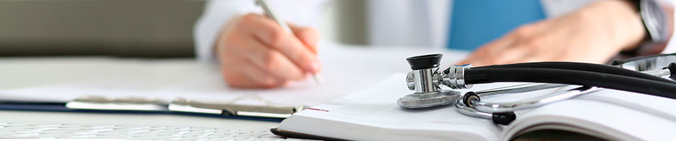 Ärztliche Instrumente im Vordergrund, ein Arzt schreibt im Hintergrund