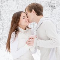Sich küssendes junges Paar in Winterkulisse