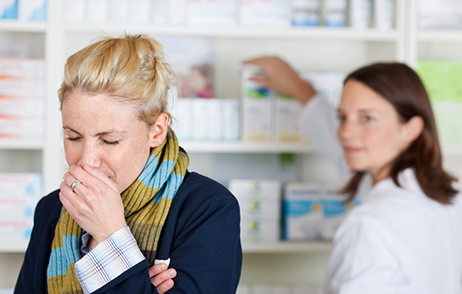 Niesende Frau in Apotheke