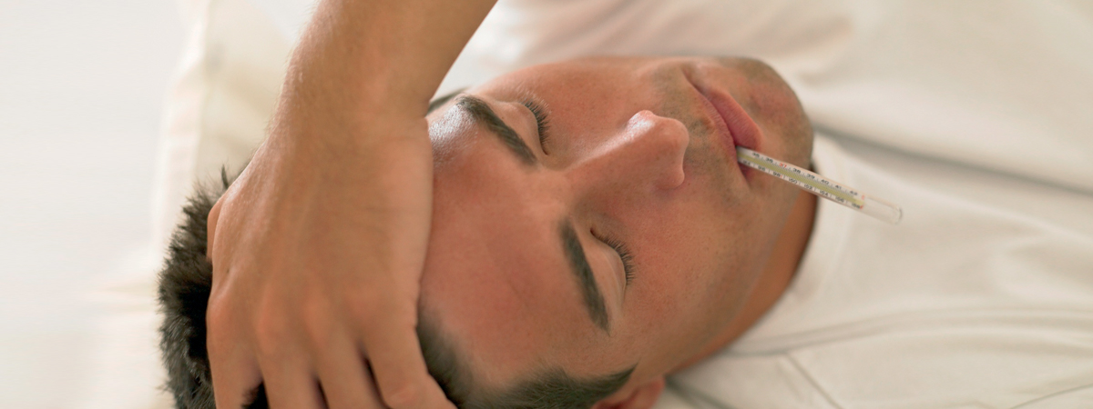 Mann mit starkem Fieber, roter Kopf