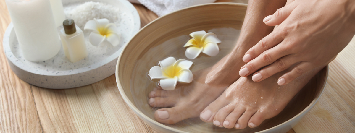 weibliche Füße in einem Bad aus Kamille
