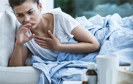 Hustende Frau im Bett