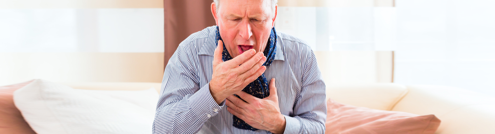 Stark hustender Mann, greift sich an Lunge