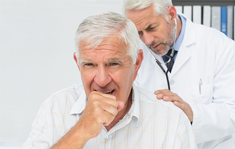 Stark hustender älterer Mann, wird von Arzt abgehört