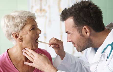 Arzt macht Halsabstrich bei älterer Frau