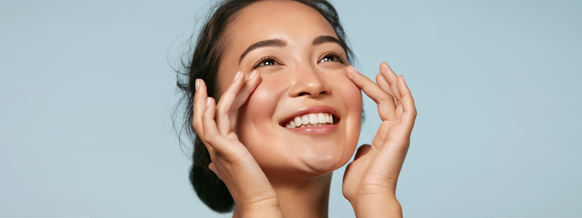 Lächelnde Frau fasst sich ins Gesicht, befreite Nebenhöhlen