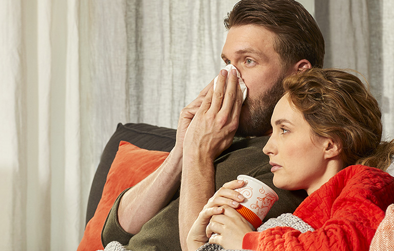 Päarchen sitzt erkältet auf der Couch