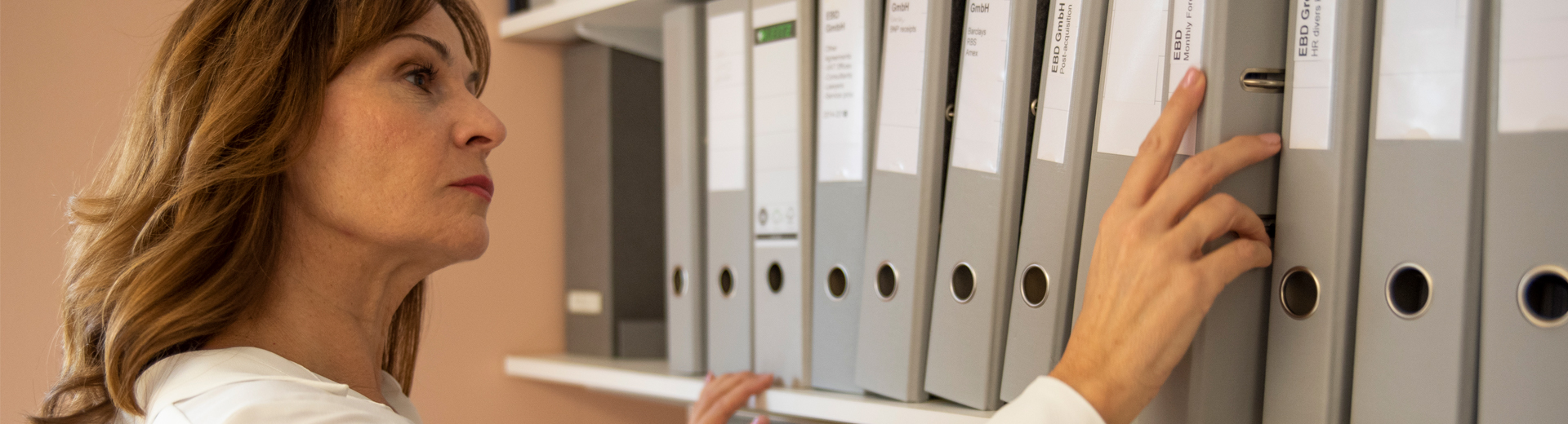 Frau sortiert Aktenordner