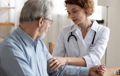 Patient mit Ärztin beim Bluttruckmessen