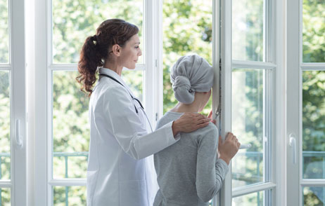 Ärztin legt den Arm um eine Brustkrebspatientin