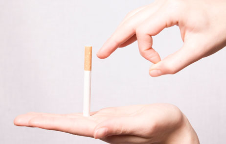 Eine Hand schnippt eine Zigarette weg