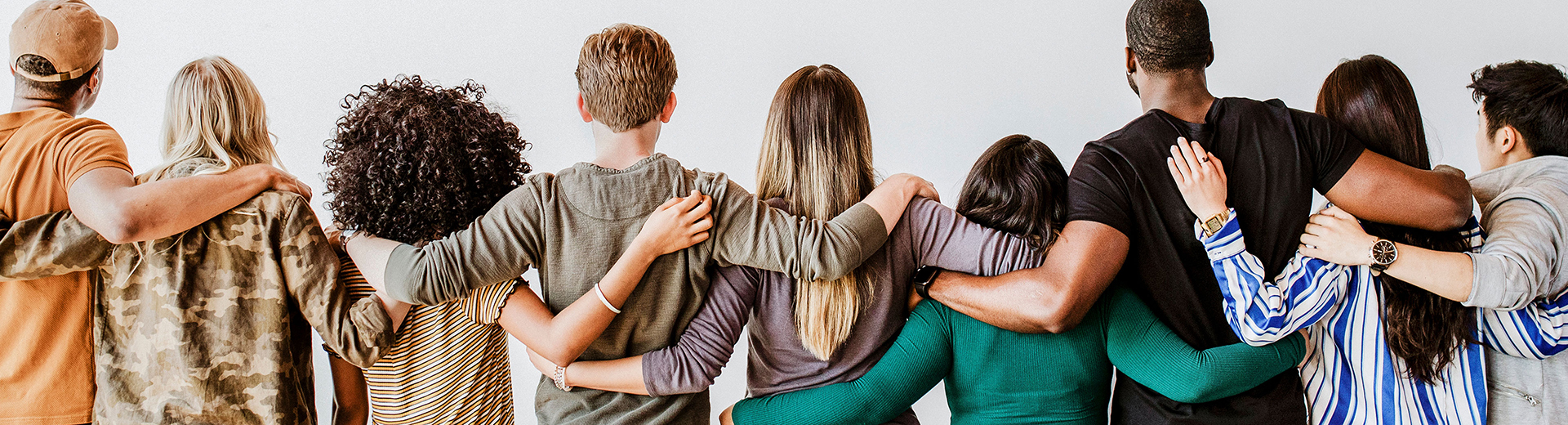 Menschen halten sich in Reihe stehend die Arme im Rücken verhakt