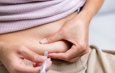 Frau spritzt sich in Bauchfalte