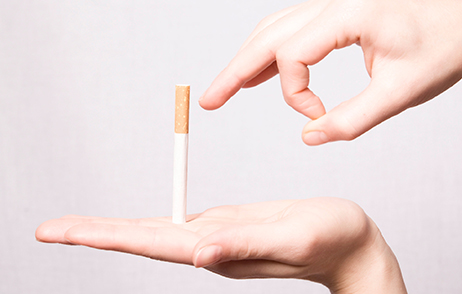 Zigarette in offener Hand, zweite Hand setzt zum Wegschnippen an