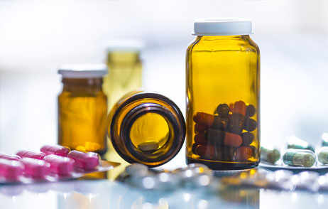 Verschiedene Tablette und Kapseln in Blistern und Glasdosen