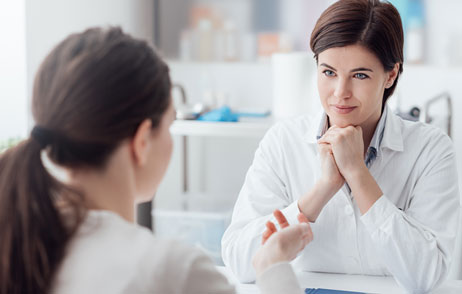 Frau spricht mit einer Ärztin