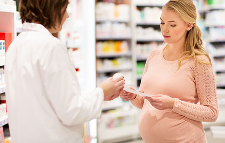 Schwangere lässt sich in der Apotheke beraten