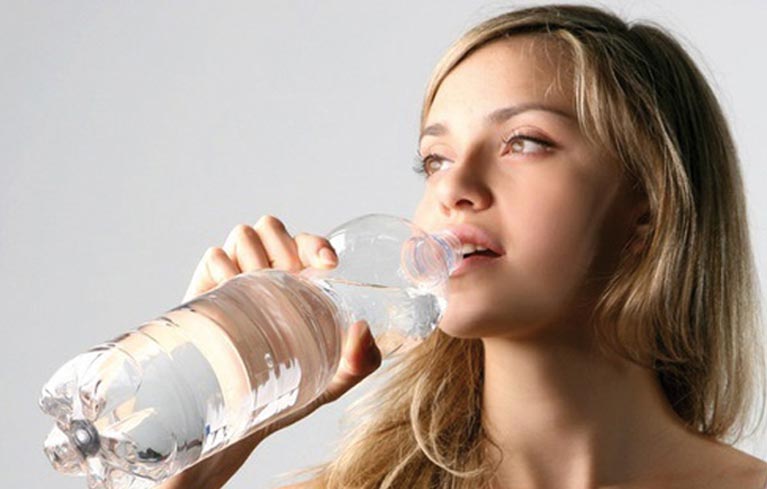 junge Frau trinkt Wasser aus der Flasche
