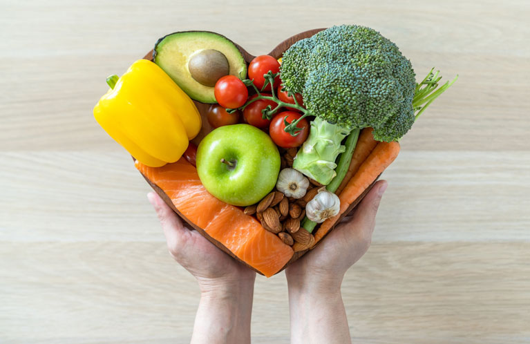 Gesunde Lebensmittel in Form eines Herzens von Händen gehalten