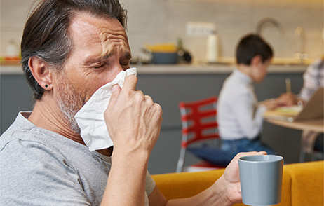 Mann niesst in Taschentuch