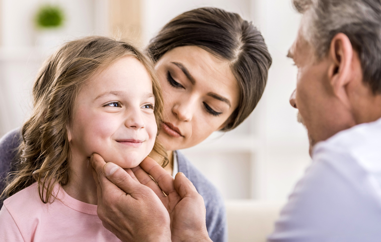Erkältung bei Kindern Mädchen wird von Arzt am Hals abgetastet