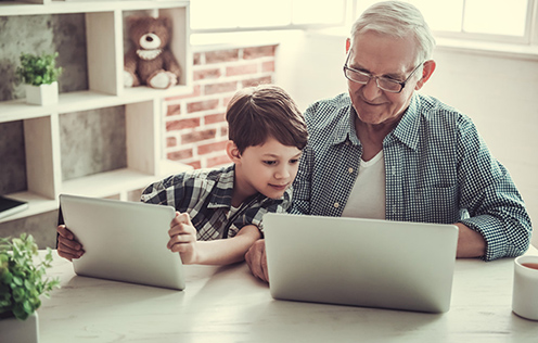 Opa und Enkel vor Computern