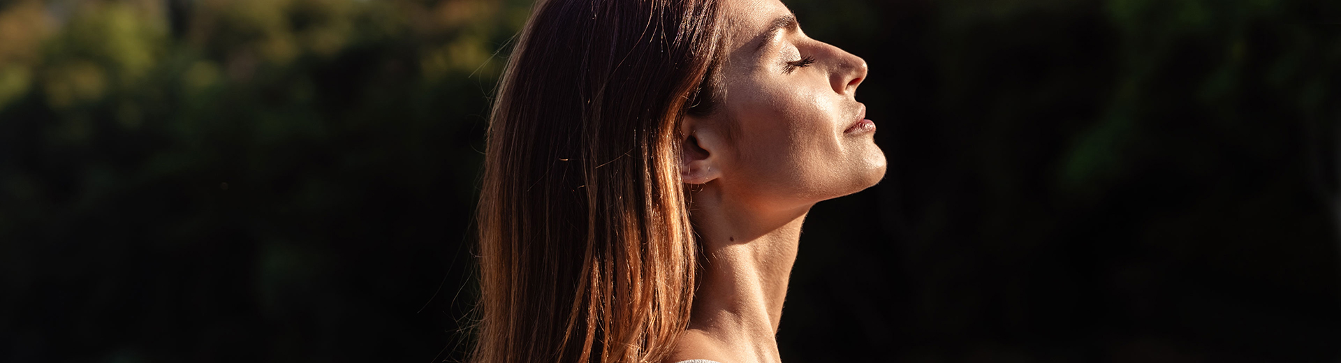 Frau genießt Sonnenlicht in ihrem Gesicht