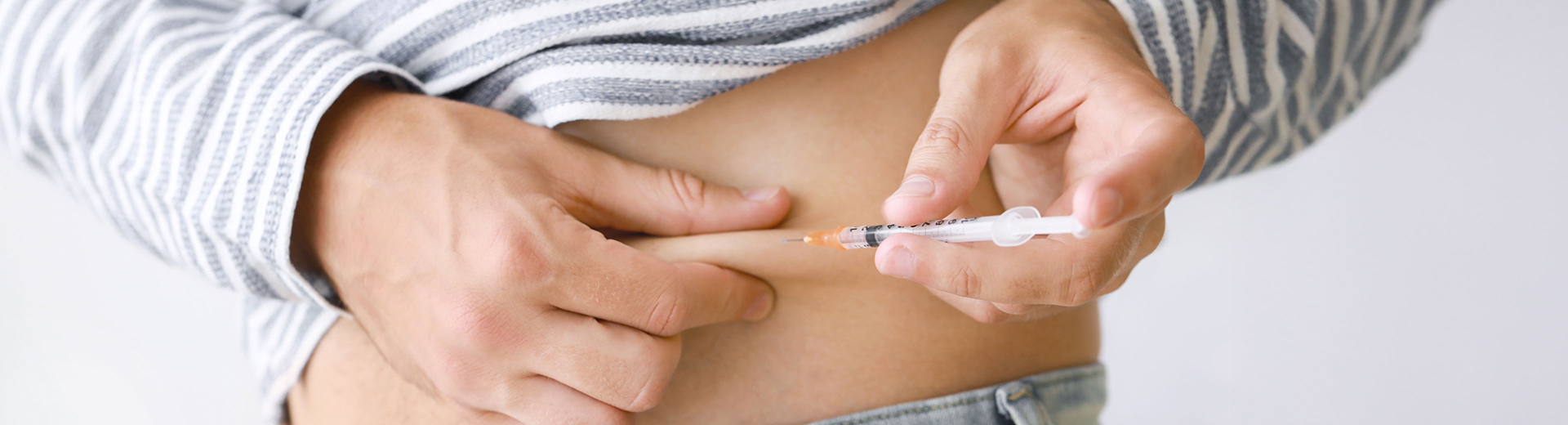 Frau spritzt sich in die Bauchfalte