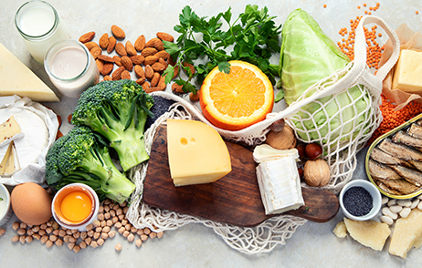 Gemüse, Käse, Hülsenfrüchte und Milchprodukte auf heller Oberfläche präsentiert