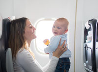 Fliegen mit Kindern Mutter mit Baby im Flieger