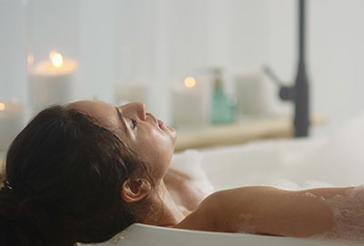 Baden entspannt die Muskulatur Frau entspannt in der Badewanne