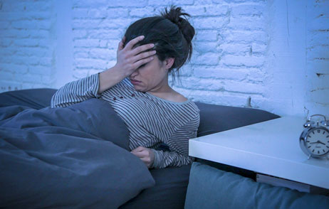 Frau liegt Nachts im Bett und kann nicht schlafen