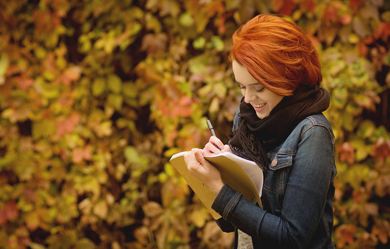 Frau schreibt in ein Tagebuch
